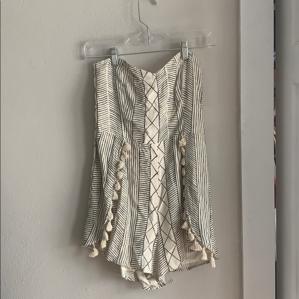 Patterned strapless romper with tassels.